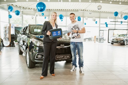 Lukas Podolski nimmt die Schlüssel für den ix35 von Melanie Weigel, Abteilung Sponsoring &amp; Kooperationen bei Hyundai Deutschland, entgegen.