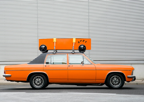 Opel Diplomat B mit 2,8-Liter-Reihensechszylinder und Automatik-Getriebe, orange-farbig foliert und mit Seifenkiste auf dem Dach für den Einsatz bei der Youngtimer-Rallye Creme 21.