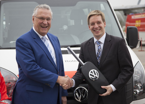 Hannes Wendler (Leiter Vertrieb an Sonderabnehmer, Volkswagen Nutzfahrzeuge, Foto re.) übergibt symbolisch einen übergroßen Schlüssel an Bayerns Innenminister Joachim Herrmann. 