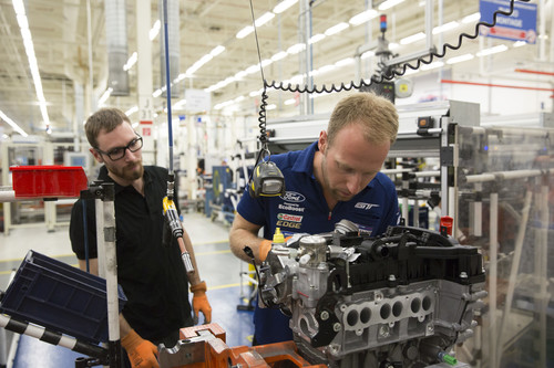 27-millionster Motor von Ford aus Köln: Werksfahrer Stefan Mücke hilft unter den Augen von Mitarbeiter Andreas Knipping bei der Montage des 1,0-Liter-Ecoboost-Motors mit.
