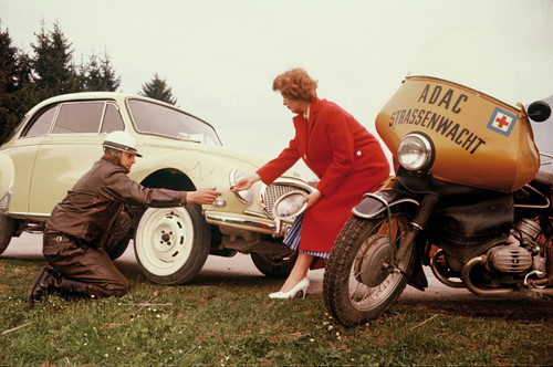 ADAC: BMW Motorrad mit Beiwagen: Reifenwechsel gehörten zu den häufigsten Pannenhilfen der Gelben Engel. Hier hilft der Straßenwachtfahrer einer Dame, deren DKW liegen geblieben war.