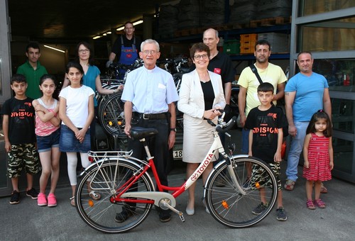 Anke Temming, Vorstandsvorsitzende der Toyota-Deutschland-Stiftung, übergab Pfarrer Franz Meurer 24 Fahrräder für bedürftige Familien.