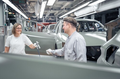 Audi erprobt in der Lackiererei ein Arbeitszeitmodell mit flexiblerer Schichtarbeit: Eileen Sterner übergibt an ihren Kollegen Thomas Rauh (v.l.n.r.) – als eine von derzeit 16 Teilnehmern des Pilotprojekts kann sie nun Beruf und Familie besser vereinbaren.