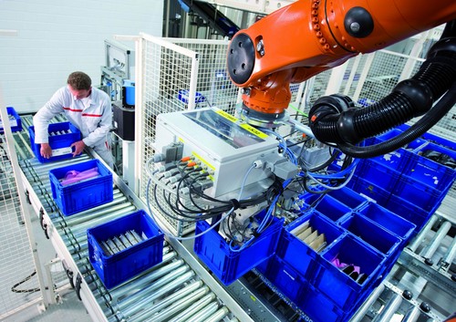 Automatisiertes Lager für Kleinladungsträger bei Audi in Neckarsulm: Roboter heben die Behälter von der Palette direkt auf das Förderband.