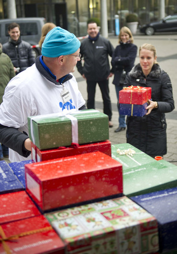 Daimler-Mitarbeiter übergeben ihre Geschenke aus der Weihnachtsaktion „Schenk ein Lächeln“.