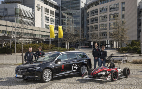 Das Formula-Student-Team „TU DART Racing&quot; der TU Darmstadt mit Opel Insignia Sports Tourer und einem Rennwagen.

