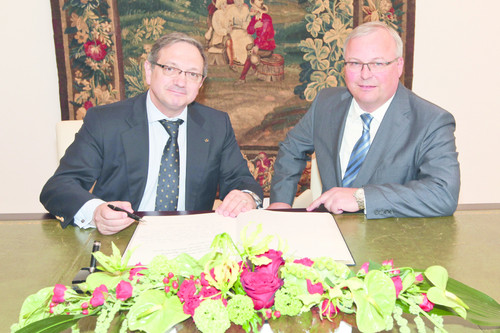 Der portugiesische Botschafter Sampaio (links) signiert in Anwesenheit von Vorstandsmitglied Waltl das Volkswagen Gästebuch.