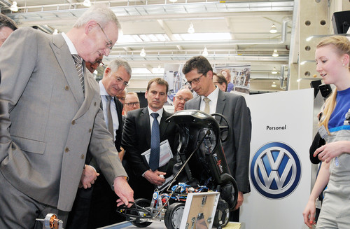 Die Auszubildende Katrin Kemmerling des Volkswagen Werks Kassel zeigt Prof. Dr. Martin Winterkorn, wie sie und andere Auszubildende aus einem Beetle-„Rutscherauto ein elektronisch ferngesteuertes Fahrzeug gebaut haben.
