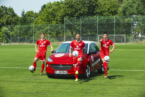 Die Mainzer Fabian Frei, Danny Latza und Ja-Cheol Koo mit dem Opel Adam in den Vereinsfarben der Rheinhessen. 