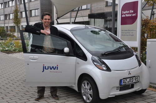 Dr. Ronald Große, der bei juwi (im Hintergrund der Firmensitz in Wörrstadt) die Abteilung Solare Mobilität leitet, fährt mit dem Mitsubishi i-Miev den ersten personenbezogenen Elektro-Dienstwagen Deutschlands.
