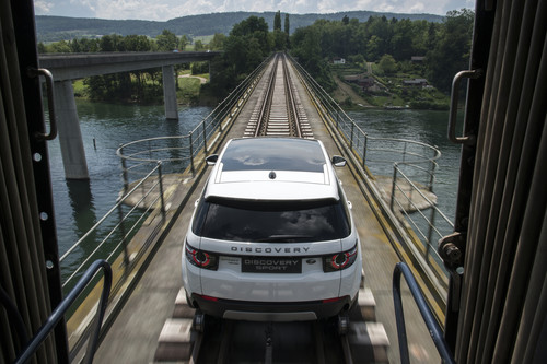 Ein Land Rover Discovery Sport zieht drei historische Eisenbahnwaggons mit über 100 Tonnen Gesamtgewicht über den Rhein.