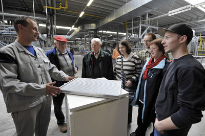 Ein VW-Mitarbeiter erklärt interessierten Besuchern Aufbau und Funktion eines gelöteten Ladeluftkühlers.