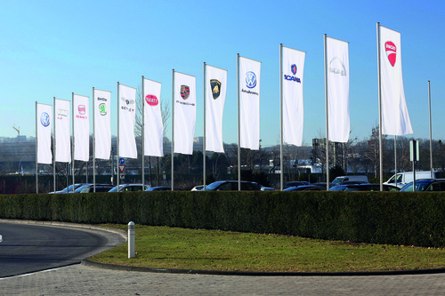 Fahnen der Konzernmarken vor dem Verwaltungshochhaus am VW-Stammsitz Wolfsburg.