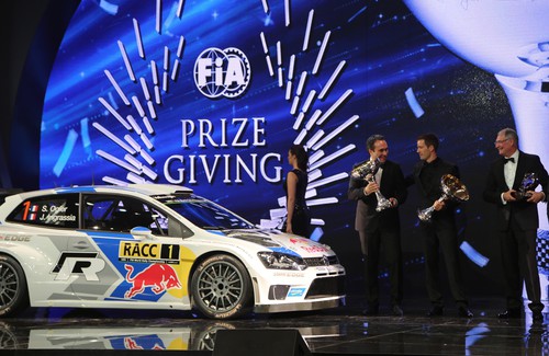 FIA-Gala der Sieger in Doha: Heinz-Jakob Neußer (rechts) und Sébastian Ogier (Mitte) mit ihren Pokalen.