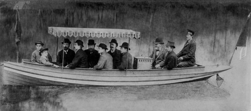 Im August 1886 unternehmen Gottlieb Daimler und Wilhelm Maybach erste Probefahrten mit Daimler-Motorbooten auf dem Neckar bei Cannstatt. Das Foto zeigt Daimler und Maybach (3. und 2. von rechts) direkt am Motorgehäuse der „Neckar“ sitzend.