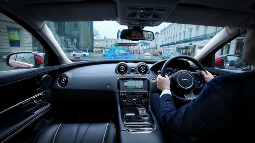 Jaguar Land Rover entwickelt eine Technologie, bei der das Navigationssyetem ein virtuelles Vorausfahrzeug in das Head-up-Display einspiegelt („Follow-Me Ghost Car Navigation“).
