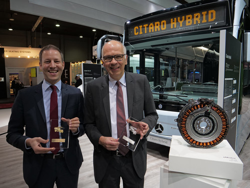 Martin Biewald (Geschäftsführer von Evobus Belgien/Evobus Niederlande) und Ulrich Bastert (rechts; Leiter Marketing, Sales und Customer Services Daimler Buses) mit zwei der vier Preise für den Mercedes-Benz Citaro Hybrid und dem Tourismo M bei der „Busworld 2017“.