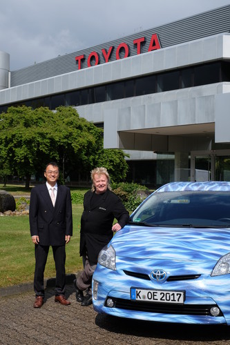 Masaki Hosoe, Chairman von Toyota Deutschland, und der Kölner Künstler HA Schult mit dem Toyota Prius für die Fahrt von Paris nach Peking.