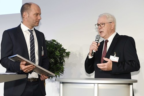Michael Lenhartz, Vorsitzender der GTÜ-Gesellschafterversammlung (links), überreicht Harald Brockmann die Ernennungsurkunde zum Ehrenvertragspartner.