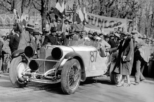 Mille Miglia 1931: Rudolf Caracciola und Wilhelm Sebastian beim Start zur n Brescia. Während der Starter die letzten Sekunden bis zum Start herunterzählt, verabschiedet sich Caracciolas Frau gerade von ihrem Mann. Alle Scheinwerfer sind gegen Steinschlag durch Abdeckkappen geschützt, 