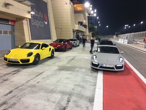 Porsche Panamera GTS warten auf der Formel 1-Strecke von Bahrain auf die Freigabe zur Nachtfahrt.