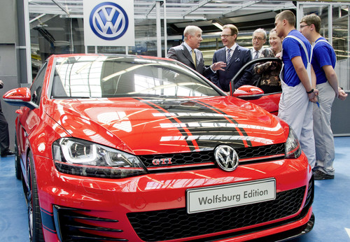 Prinz Andrew unterhält sich mit den VW-Vorständen Dr. Michael Macht und Dr. Horst Neumann über den Golf GTI Wolfsburg Edition, der von Auszubildenden aufgebaut worden ist. 