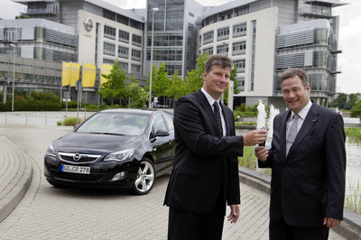 Prof. Dr. Ing. Hans-Christian Reuss von der Universität Stuttgart (rechts) nimmt den Opel Astra als Versuchsträger für den geplanten Fahrzeugsimulator vom Direktor der europäischen Vorausentwicklung, Marc Schmidt, entgegen.
