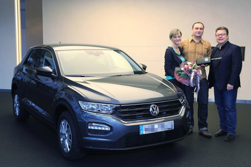 Roman Schell (Mitte) aus Wolfsburg und seine Frau Nelli nahmen als erste Kunden in der Autostadt von Andreas Brüsch, Leiter Verkauf an Mitarbeiter der Marke Volkswagen, einen T-Roc in Empfang.