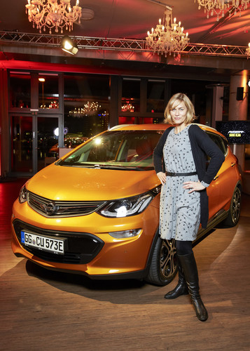 Schauspielerin Gesine Cukrowski an einem Opel Ampera-e.