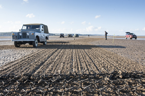 Sechs Land Rover Defender unterschiedlicher Baujahre zeichneten mit Eggen den überdimensionalen Umriss des legendären Geländewagens in den Sand von Anglesey.