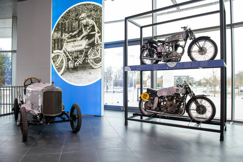  Sonderausstellung „Der fünfte Ring“ im Audi-Museum: Das Foto im Hintergrund zeigt Gertrude Eisemann – die „Meisterin des Motorrads“ – auf einer NSU 2 PS. Sie gewann damit 1905 als erste Motorradfahrerin die Fernfahrt „Eisenach-Berlin-Eisenach“ bei einer Durchschnittsgeschwindigkeit von 42 km/h.