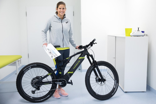 Tennisprofi Julia Görges mit einem Porsche Design E-Bike, das Mitarbeiter leasen können.