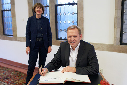 Toyota-Deutschland-Präsident Alain Uyttenhoven trägt sich auf Einladung von Oberbürgermeisterin Henriette Reker in das Gästebuch der Stadt Köln ein.