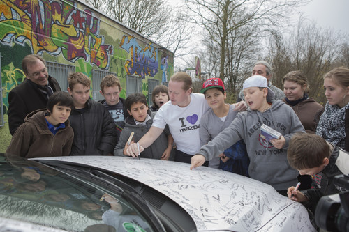 Übergabe des Mazda6 an die SOS-Kinder- und Jugendhilfen Düsseldorf (von links): Markenbotschafter Joey Kelly (Mitte) signiert das Fahrzeug.