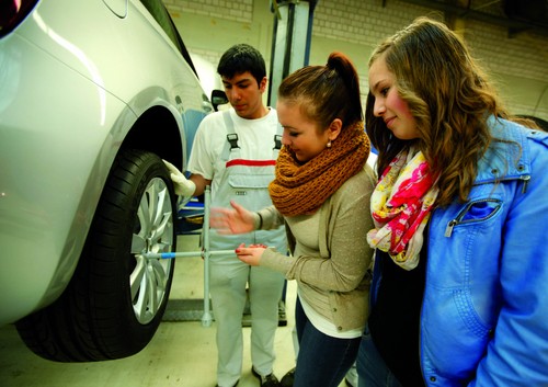 Unter Anleitung eines Auszubildenden wechseln die Mädchen bei Audi in Neckarsulm den Reifen an einem Audi A1.