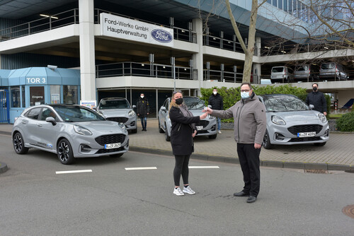 Vier Ford Puma für Fahrten von Senioren zu ihren Impfterminen: Heinz-Georg Oebels (Leiter Events, Messen und Sponsoring der Ford-Werke) übergibt die Fahrzeuge an Leanda Ergin von der Charity Alliance.