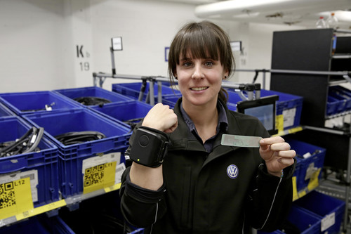 Volkswagen-Mitarbeiterin Isabell Pfeiffer kommissioniert Material mit Hilfe eines RFID-Armbands.