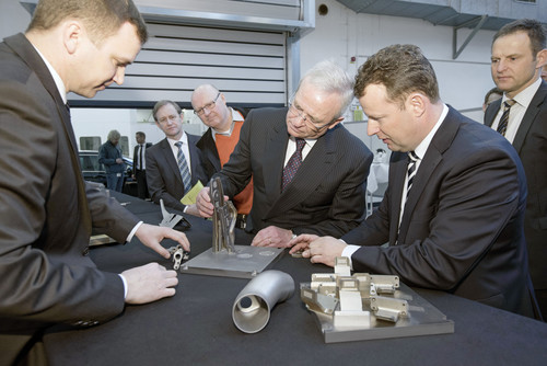 VW-Konzernvorsitzender Prof. Dr. Winterkorn schaut sich ein mit dem metallischen 3-D-Drucker hergestelltes Bauteil an.