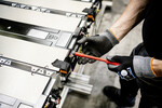Ein Mitarbeiter montiert im Mercedes-Benz-Werk Mannheim das Steuergerät an das Batteriepaket für den e-Actros, der in Wörth gebaut wird.